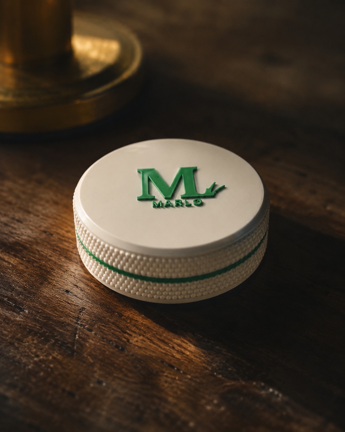 A MARLO pouch tin — white with a green mark and knurled grip