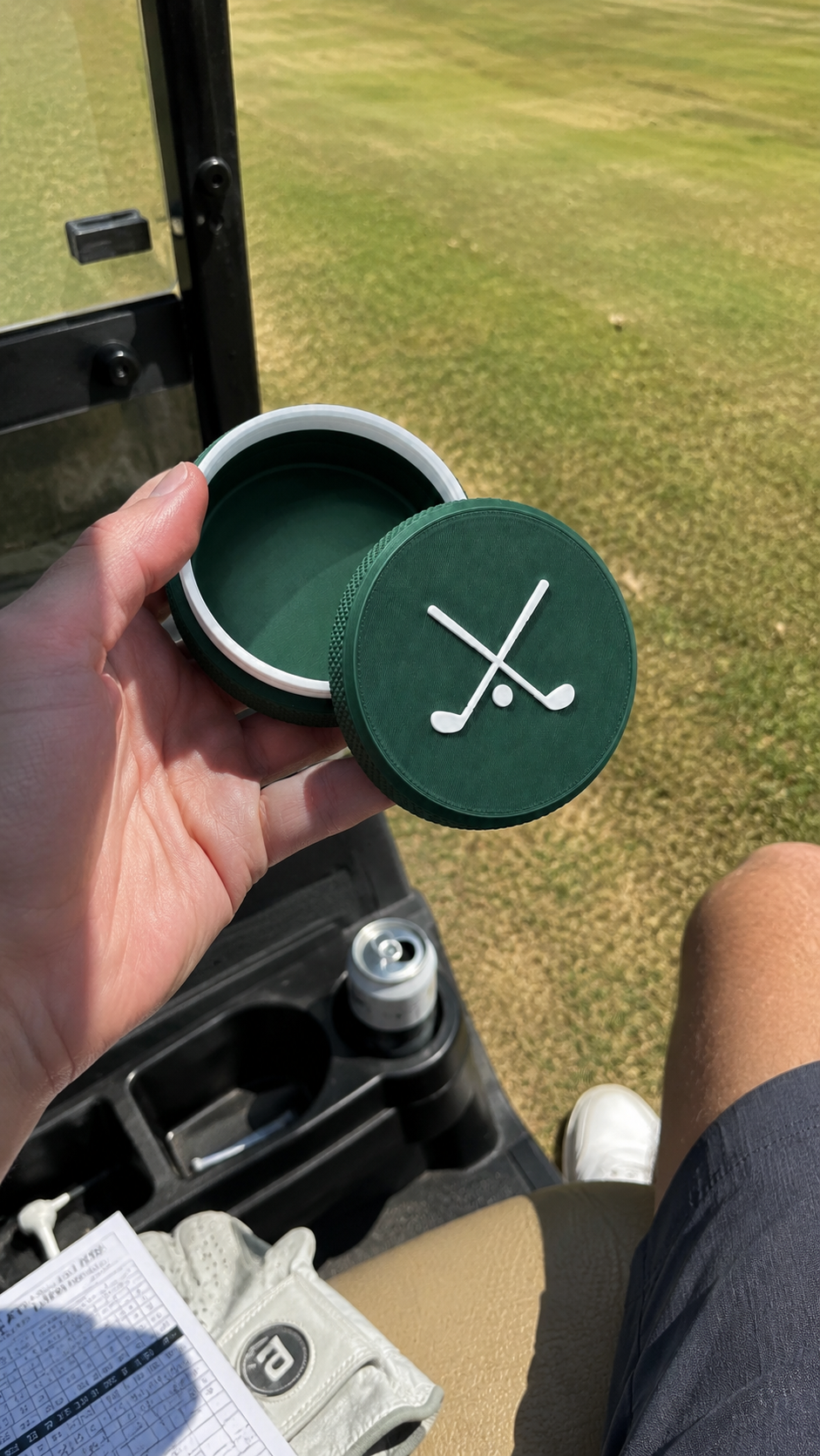 The Back Nine tin in hand on a golf cart