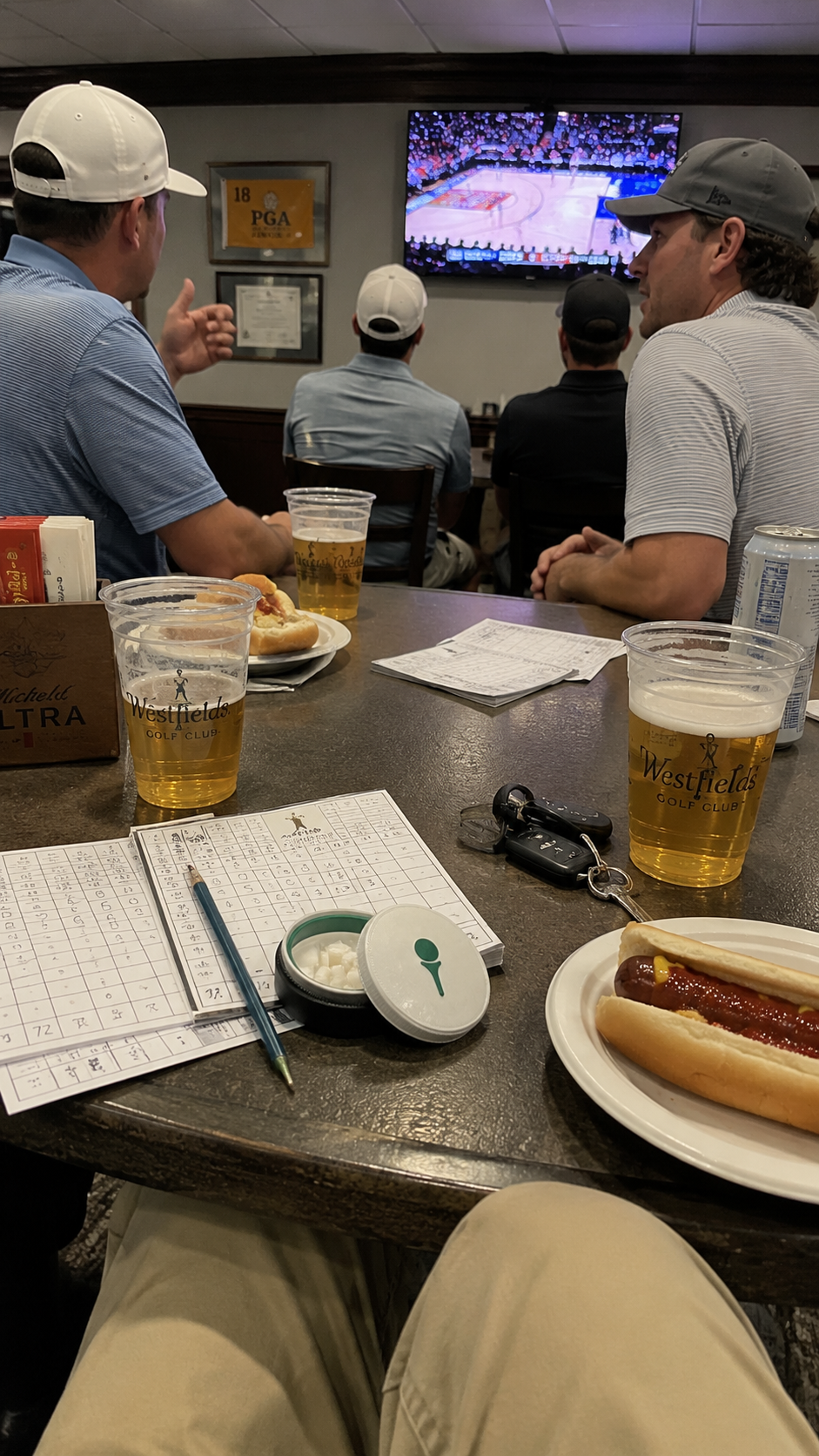 The Tee Box tin on the clubhouse table with scorecards